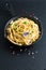 Food concept homemade spaghetti creamy white sauce in cast-iron skillet pan on slate stone