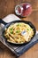 Food concept homemade spaghetti creamy white sauce in cast-iron skillet pan on wood