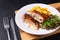 Food concept Homemade Veal cordon bleu with salad and french fried in white ceramic plate on wooden board and black slate stone