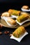 Food concept Oriental arab dessert baklava walnuts and rolled Kanafeh on black slate board with copy space
