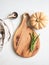 Food cooking concept. Beige pumpkin, wood cutting board for menu or recipe and fresh rosemary branches on the kitchen table. Top