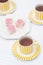 Food : Cups of tea and a plate of pink iced sponge cakes. 6