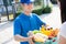 Food Deliver Asian man in blue uniform give fruit and vegetable to receiver customer front house