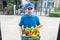 Food Deliver Asian man wearing mask in uniform give fruit and vegetable to receiver customer