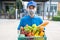 Food Deliver Asian man wearing mask in uniform give fruit and vegetable to receiver customer front house