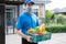 Food Deliver Asian man wearing mask in uniform give fruit and vegetable to receiver customer front house