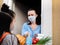 Food delivery during a pandemic and strict quarantine. A teenage volunteer girl delivered a basket of food to a woman in