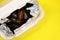 Food delivery in plastic packaging to your home. Mussels in sauce in foil and plastic container on a yellow background