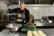 Food delivery in the restaurant. Caucasian woman chef in uniform in a kitchen in a restaurant pours salad with cabbage