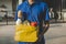 Food delivery service man in blue uniform holding fresh food set bag waiting for customer