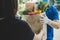 Food delivery service man in blue uniform wearing protection face mask holding fresh food set bag to customer at door home