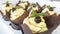 Food desserts cupcakes with mint, black chocolate, lemon with yellow lemon filling on a black table in white packaging. Sweets in