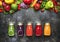 Food and drink background. Colorful vegan vegetable juices and smoothies set in bottles on gray kitchen table, copy space,