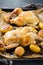 Food and drink, holidays eating dinner concept. Roasted chicken poussin with spices, herbs, garlic and small potatoes on a kitchen