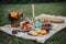 food and drink on a table outdoors in the woods with candles