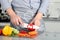 Food, family, cooking and people concept - Man chopping paprika on cutting board with knife in kitchen