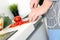 Food, family, cooking and people concept - Man chopping paprika on cutting board with knife in kitchen