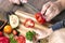 Food, family, cooking and people concept - Man chopping paprika on cutting board with knife in kitchen with daughter