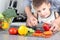 Food, family, cooking and people concept - Man chopping paprika on cutting board with knife in kitchen with son