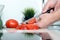 Food, family, cooking and people concept - Man chopping tomato on cutting board with knife in kitchen