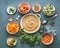 Food flat lay with couscous and vegetarian cooking ingredients in bowls on gray background