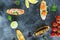 Food frame made of sandwiches with prawn, salmon, mushroom and limes on dark background. Restaurant food