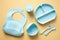 Food grade silicone baby self feeding utensils set on color background. Flat lay, top view