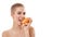 Food for healthy skin. Portrait of young and happy attractive blonde woman with short haircut eating a piece of orange