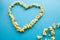 Food. Image of the Heart Forms from Popcorn. Delicious Popcorn on Blue Background. Cinema.