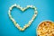 Food. Image of the Heart Forms from Popcorn. Popcorn Bucket. Delicious Popcorn on Blue Background. Cinema.