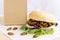 Food Insects: Silkworm Pupae insect deep-fried for eating as food in bread burger with vegetable and package bag on wooden table,