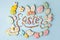 Food Lettering EASTER Colorful easter cookies on blue background, assortment sweet gifts, seasonal springtime holiday greeting