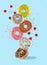 Food levitation - sweet colorful donuts flying in the air with raspberries and colored sprinkles