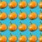 Food pattern with arrangement of orange pumpkins on turquoise background