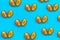 Food pattern of halves of ripe blue plum with bone on bright turquoise paper,