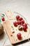 Food photo: branch of red grapes and walnuts on wooden board, on light background, close-up. Sloppy still life.