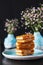 Food photo three delicious wafers with white filling in the pale blue bowl vases with baby`s breath