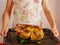 Food photo of unrecognizable man in apron is holding fried chicken