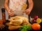 Food photo of unrecognizable man cooking chicken in the kitchencook in apron with rope