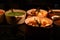 Food photography image of large pans or pots filled golden color crispy roast potatoes green peas and gravy on a dark surface