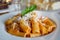 Food photography of an Italian pasta dish with a tomato and cream sauce with artichokes and parmesan cheese