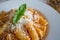 Food photography of an Italian pasta dish with a tomato and cream sauce with artichokes and parmesan cheese