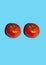 Food poster with two tomato looks like eyes on blue background. Creative concept with tomato