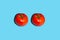 Food poster with two tomato looks like eyes on blue background. Creative concept with tomato