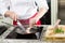 Food preparation chef cook in kitchen with pan over stove doing