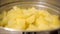 Food preparation footage- A close up of steaming potatoes in a stainless steel steamer pot