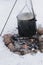 Food preparation in huge black bowl on bonfire in winter time