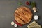 Food seasoning background. Menu, recipe, mock up. Round wooden cutting board on dark backdrop