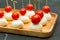 Food snacks and appetizers for buffet. Canapes with mozzarella cheese and cherry tomatoes served on wooden tray