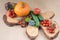 Food still life with tiny tomatoes, yellow pumpkin, green cucumber, decorated on rustic tree slice